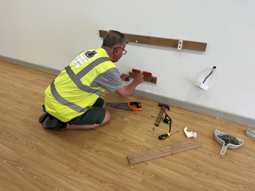 Richard fastening the heater back on the wall
